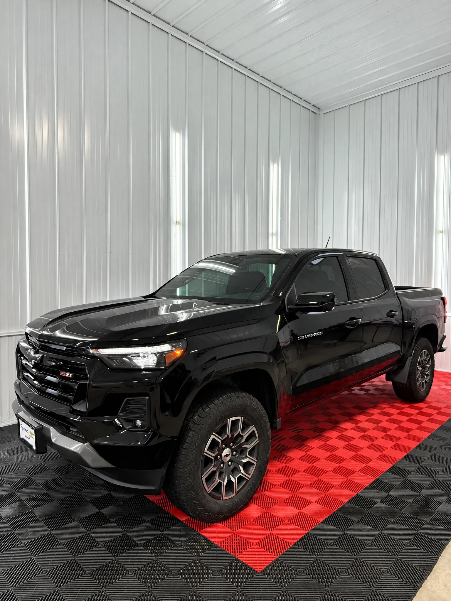 Black Chevrolet Colorado pickup with tinted windows in the OnPoint Tintz bay