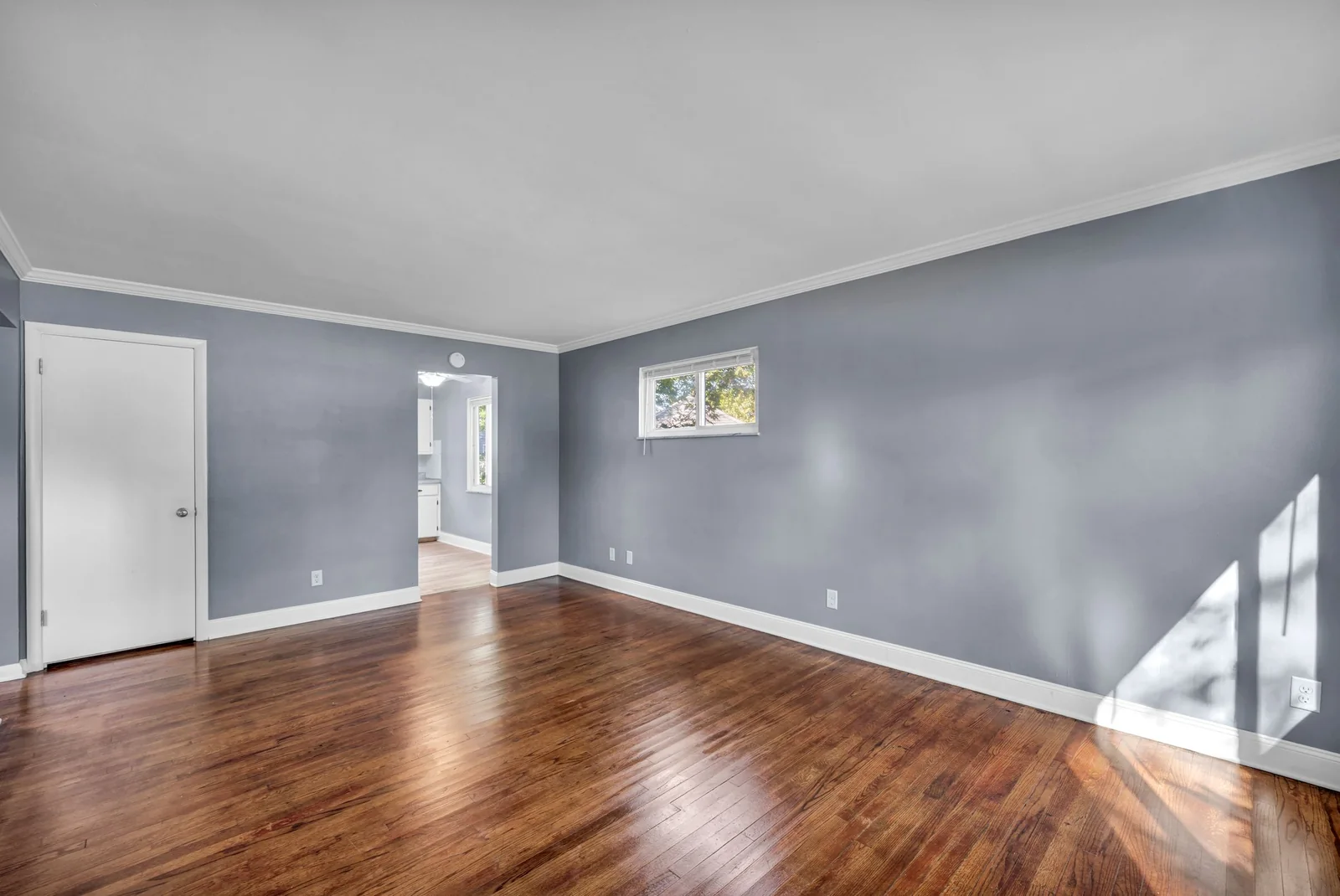 Bright and spacious empty living room with hardwood floors, ideal for a new beginning.